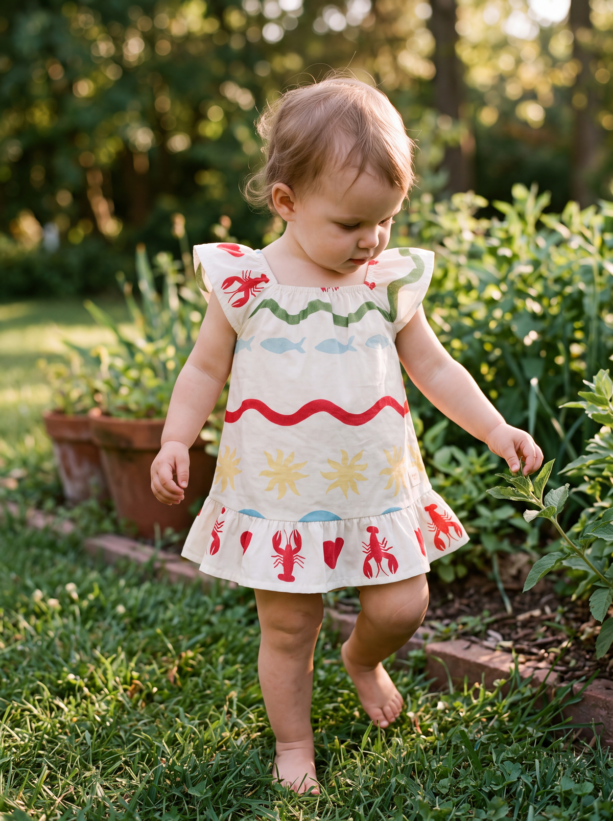 Vestido Día de Playa de Bugbee en una niña caminando descalza en el jardín